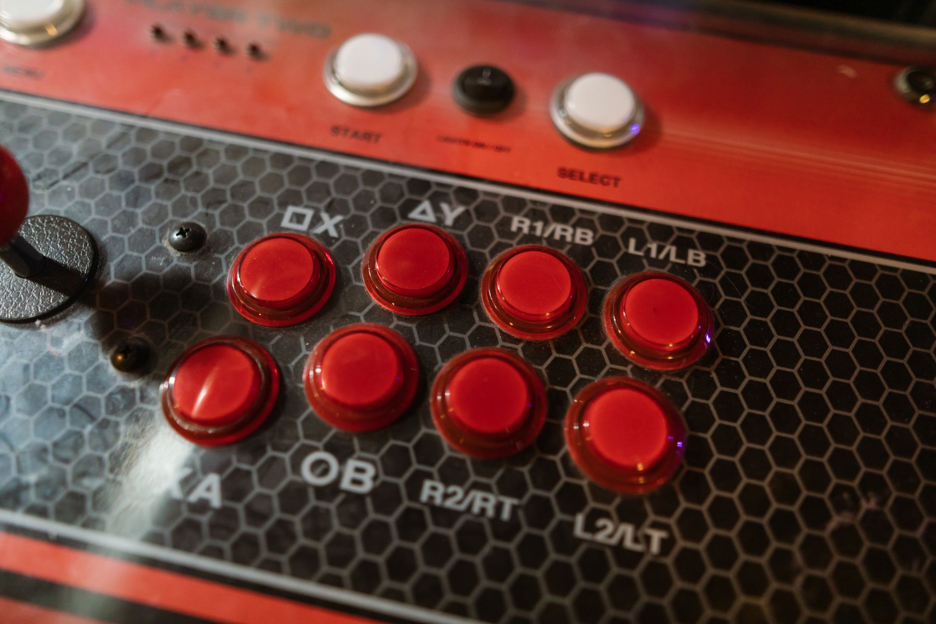 Vue détaillée du panneau de commande d'une borne d'arcade rétro avec des boutons colorés et un joystick.
